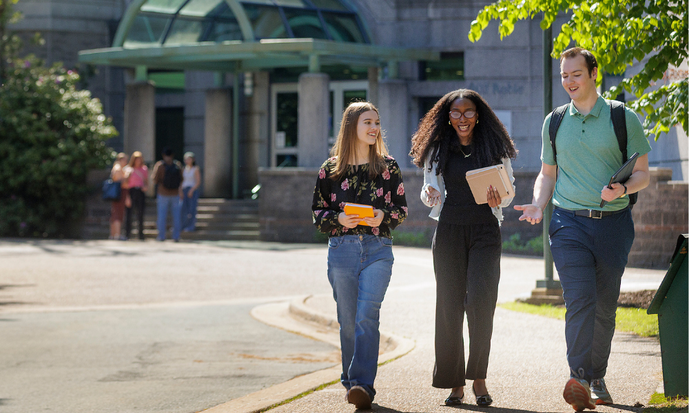 Three students walk together in front of the Sobey Building